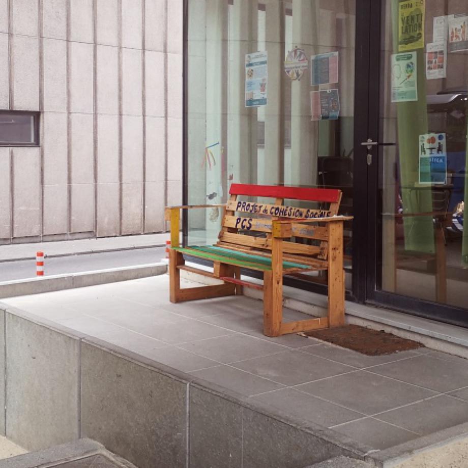 Un banc coloré avec écrit "Projet de cohésion sociale"