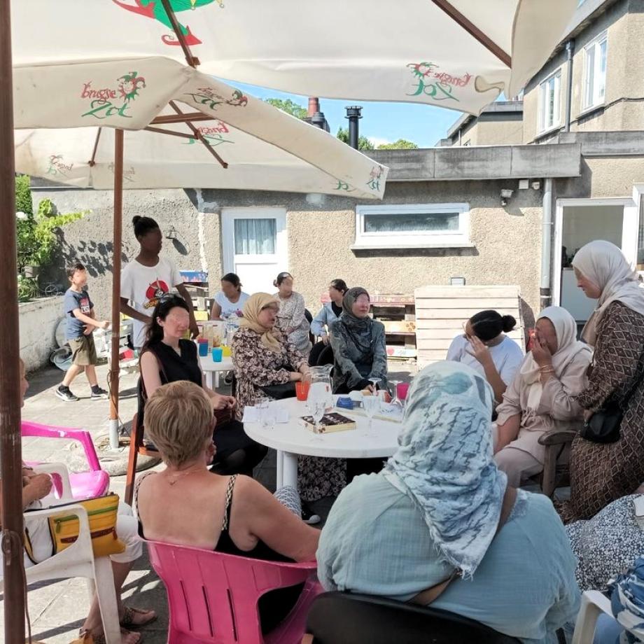 Fête de quartier avec des femmes en train de discuter autour d'une table
