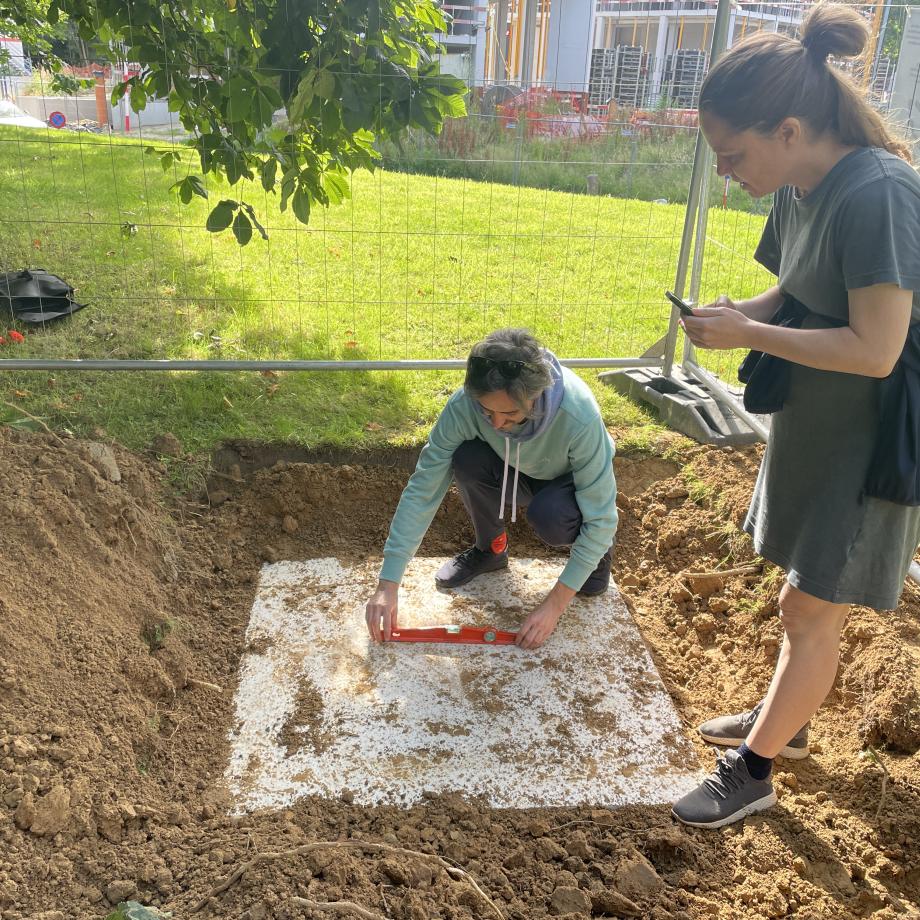 Deux personnes prennent des mesures sur le sol
